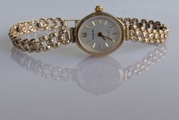 A ladies Accurist quartz dress watch with oval dial, baton markers on a 9ct gold case and fancy-link
