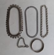 Three elaborately carved silver neck chains, a curb-link bracelet with heart locket 