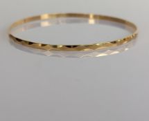 An 18ct yellow gold bangle with faceted decoration, 70mm, hallmarked, 7g