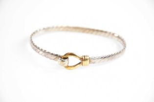 An 18ct yellow gold and silver bangle, with wrythen twist detail to the band and spring action for