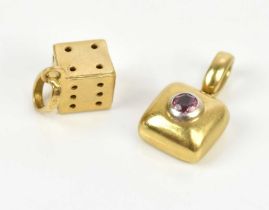 A yellow metal dice charm, stamped '750', approx 1.1g, and a yellow metal charm, indistinctly