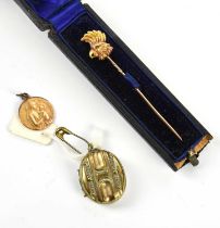 A yellow metal pendant representing Madonna and Child, a Victorian yellow metal cased stick pin,