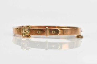 A yellow metal hinged snap bangle with buckle form design, unmarked, approx 9.6g.