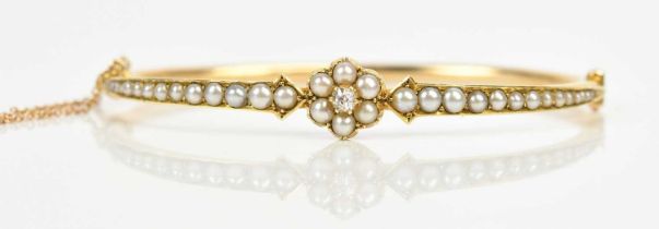 A Victorian yellow metal seed pearl and diamond set snap bangle, width 6cm, approx 9.4g. Condition