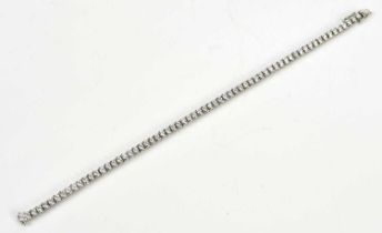 A white metal diamond set tennis bracelet, stamped '750', set with sixty-five diamonds, each