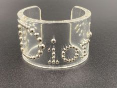 CHRISTIAN DIOR, a signed Perspex and silvered stud work cuff bracelet,&nbsp;