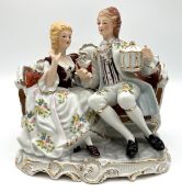 Elegantes Figurenpaar auf Sofa sitzend