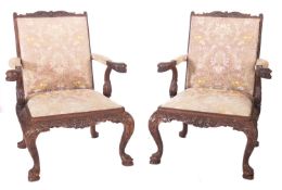 A pair of South East Asian carved hardwood library armchairs.