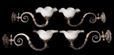 A set of four silvered metal and milk glass wall appliques,