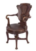 An Edwardian oak revolving office armchair, the cartouche shaped back with shell ornament,