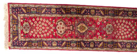 A Turkish runner, the rose field with a design of cartouche medallions and floral sprays,