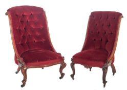 Two similar Victorian nursing chairs in carved rosewood and walnut,