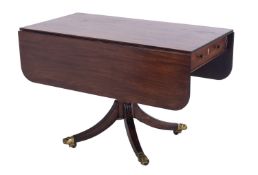 A Regency mahogany drop flap breakfast table, the hinged top with a reeded edge and rounded corners,