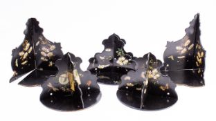 A set of five Victorian painted and black lacquered papier mache wall brackets,
