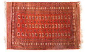 A Pakistan rug of Turkoman design, the light brown field with three rows of quartered guls,