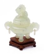 A Chinese carved green hardstone tripod censer and cover with mythical beast finial and loose-ring