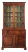 A mahogany bookcase in the Georgian manner, the upper part with a moulded dentil cornice,