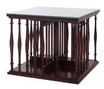 An Edwardian mahogany square revolving table bookcase, with shaped square section uprights,