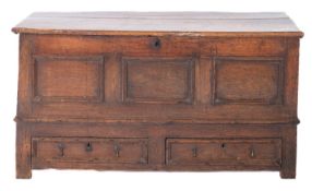 An 18th Century oak rectangular dower chest, with a hinged moulded top and triple panelled front,