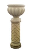 A stone composition urn on pedestal, probably by Haddonstone,