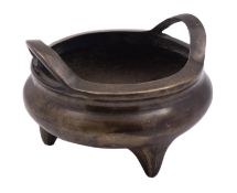 A Chinese bronze censer of bombe shaped form with lug handles and three peg feet,