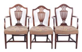 A set of three George III mahogany dining chairs, in the Hepplewhite manner,
