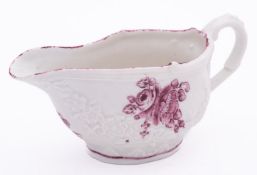 A Champion's Bristol sauceboat with relief moulded festoons and painted in puce camaieu with flower