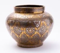 A Cairo-ware silver and copper inlaid brass bowl decorated with arabesques and roundels with Arabic