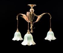 A brass and vaseline glass three light electrolier in Arts & Crafts taste and in the manner of W.A.
