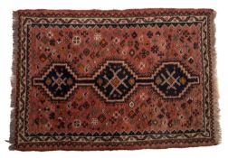A Shiraz rug, the rose field with a row of triple stepped indigo hexagonal medallions,