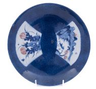 A Chinese underglaze blue and copper-red saucer dish, Kangxi decorated with two fan-shaped panels,