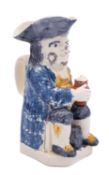 A Staffordshire creamware toby jug holding a foaming jug with a barrel between his legs and pipe to