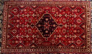 A Qashgai carpet, the wine field with a central indigo shaped lozenge pole medallion,