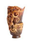 A Chinese archaistic carved buffalo horn libation cup with relief carved chilong handle,