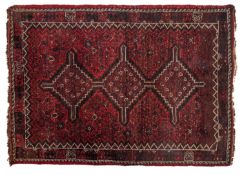 A Shiraz rug, the wine field with a row of triple stepped and pointed lozenge medallions,
