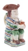A rare Staffordshire creamware 'striped coat' toby jug modelled holding a brown foaming jug,