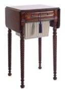 A Regency mahogany drop flap work table, the hinged top with rounded corners and a reeded edge,