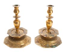 A pair of Dutch brass candlesticks, 17th century; with bulbous sockets and urn cast stems,