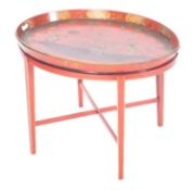 A red lacquered and parcel gilt oval papier mache tray on stand, in Regency taste,