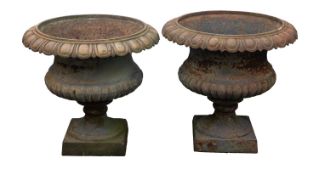 A pair of cast iron garden urns, 20th century; of Campana form,