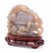 A Chinese agate 'dragon and peach' carving the two dragons climbing over the peach in pursuit of a