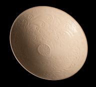 A Chinese Ding-ware 'Dragon' bowl, Song dynasty of conical form with short footrim,