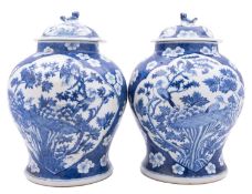 A pair of Chinese blue and white baluster jars and covers, late Qing Dynasty with lion dog finials,