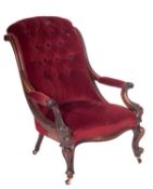 A Victorian carved mahogany open armchair, with upholstered button down curved back,