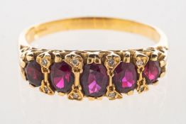 A five stone ruby ring, a scroll carved