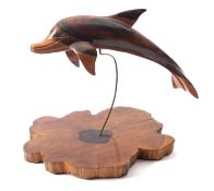 A carved and stained wood, probably olivewood model of a dolphin, modern; naturalistically modelled,
