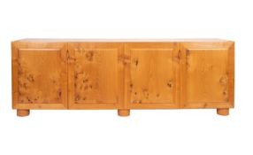A contemporary oak sideboard; with four cushion panel doors, on short drum feet; 75cm high,