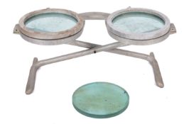 A cast metal and glass two seat chair in the form of a pair of sunglasses, reputedly for Hugo Boss,