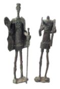 Two similar metal alloy models of standing figures,