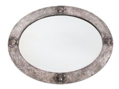 A silvered copper framed oval wall mirror in Arts & Crafts taste,